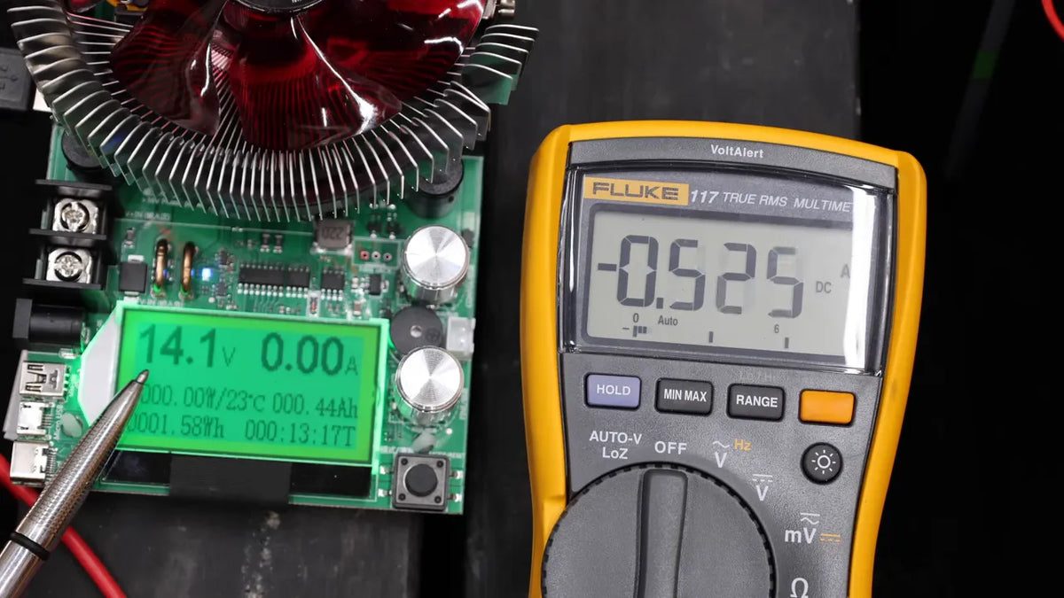 Multimeter reading and solar battery maintainer controller display showing voltage during overcharge testing