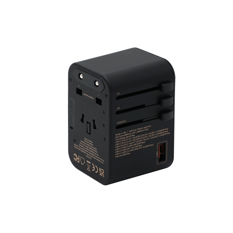 The 65W GaN Travel Adapter is a black fast charger with USB port and sliding switches for EU, UK, US/AUS plugs. Printed specs on the side make it ideal for international travel.