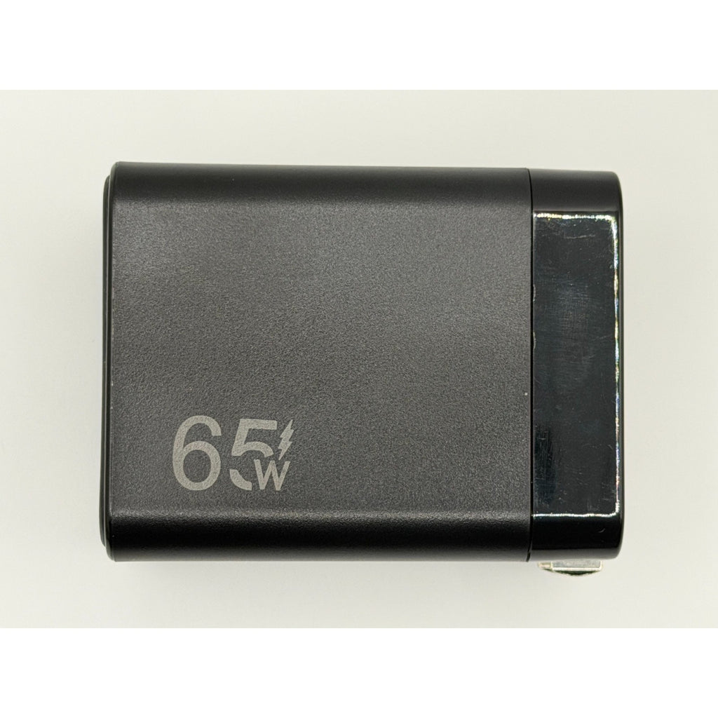 The 65W GaN USB-C Wall Charger with Built-In Cable & Foldable Plug is a black rectangular fast charger, shown from above on a plain background—ideal for quickly charging multiple devices with its compact, portable design.