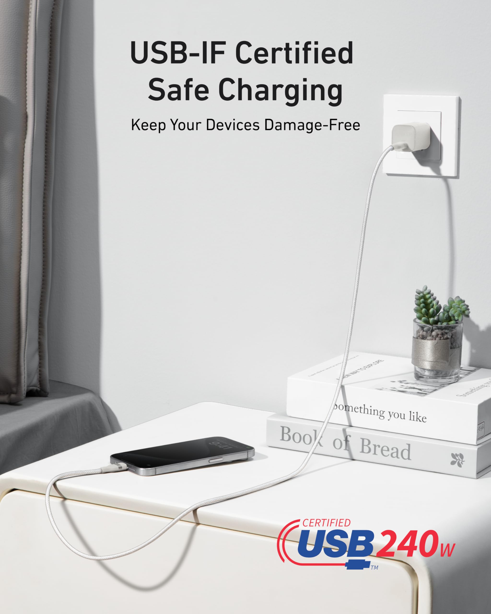 An Anker USB-C to USB-C Cable (3 ft / 6 ft, 240W, Upcycled-Braided) charges a smartphone on a white nightstand. Nearby are two books, including "Book of Bread." Text: "USB-IF Certified Safe Charging" and "Certified USB 240W.