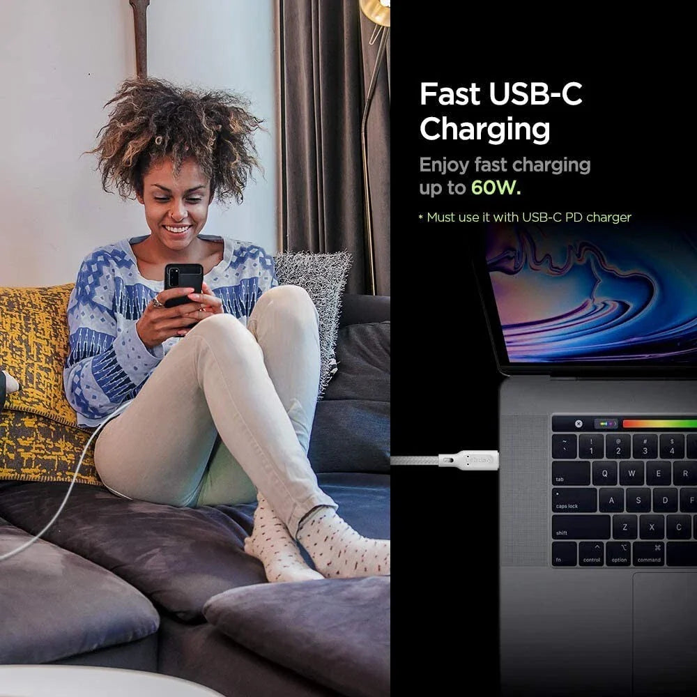 A woman smiles at her phone while it charges with the Spigen DuraSync 60W USB C to USB C High Speed Fast Charging Cable (4.9FT, 2 Pack). Text beside her reads: "Fast Charging—up to 60W.* Use with USB-C PD charger," with a laptop charging nearby.