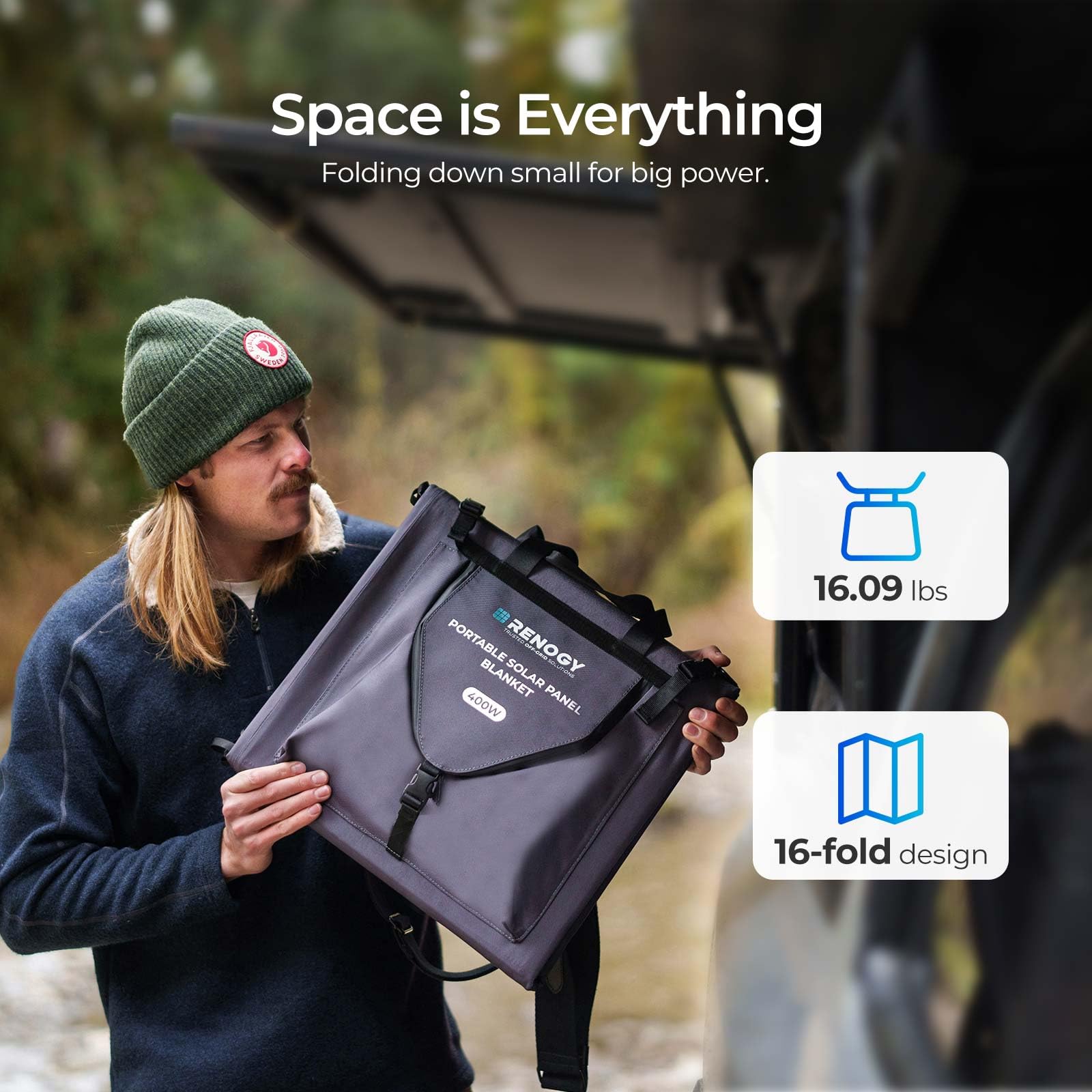 A person stands beside a vehicle, holding a folded Renogy 400W Portable Solar Panel Blanket – 25% Efficient N-Type Foldable Solar Charger for Power Stations, RVs & Off-Grid Power. The text reads, "Space is Everything." Below, icons display "16.09 lbs" and "16-fold design," emphasizing the lightweight and highly portable off-grid power solution. The scene features an outdoor backdrop with a soft focus.