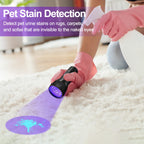 Wearing pink gloves, a person uses the Vansky Black Light UV Flashlight (51 LED, 395nm) to reveal a blue pet urine stain on a white rug—perfect for spotting dog or cat accidents on carpets and sofas. Batteries included.