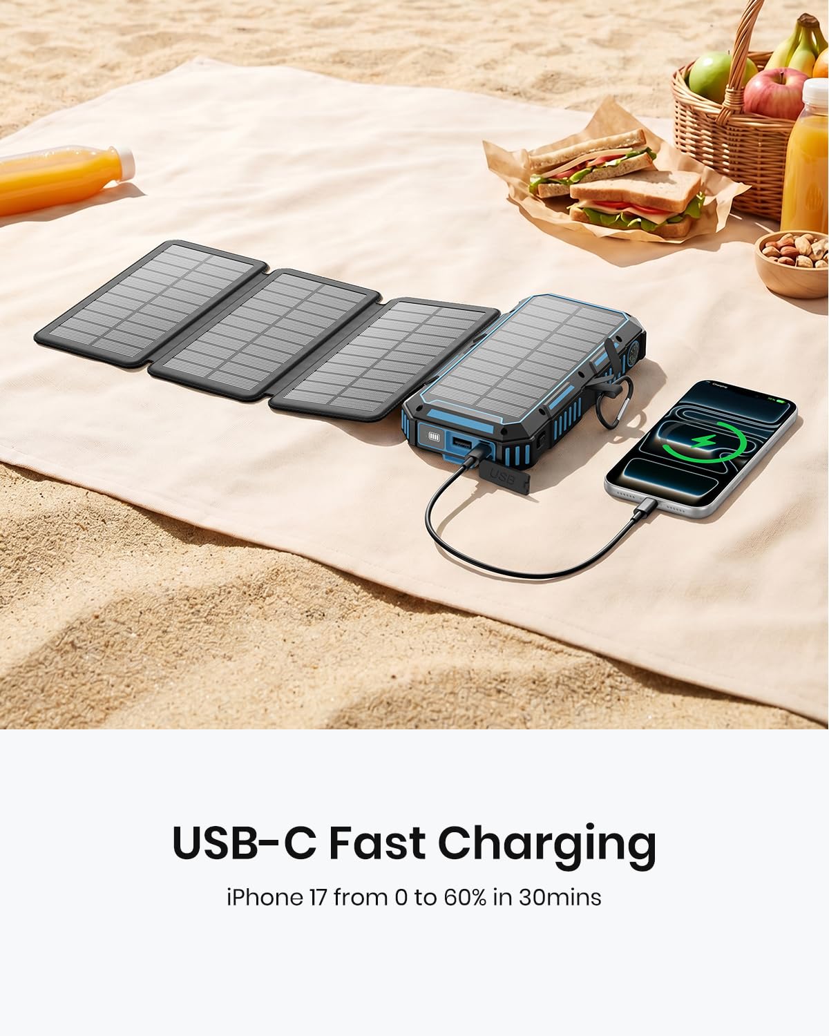 Relaxing on a sandy beach with snacks, a drink, and a picnic basket, your smartphone stays charged thanks to the 50000mAh Solar Power Bank – Magnetic Wireless Charger with Hand Crank, 4 Solar Panels & Built-In Charging Cables. Designed for reliable backup power wherever you are, it keeps you connected even off the grid. Text overlay: “USB-C Fast Charging. iPhone 17 from 0 to 60% in 30 mins.”.