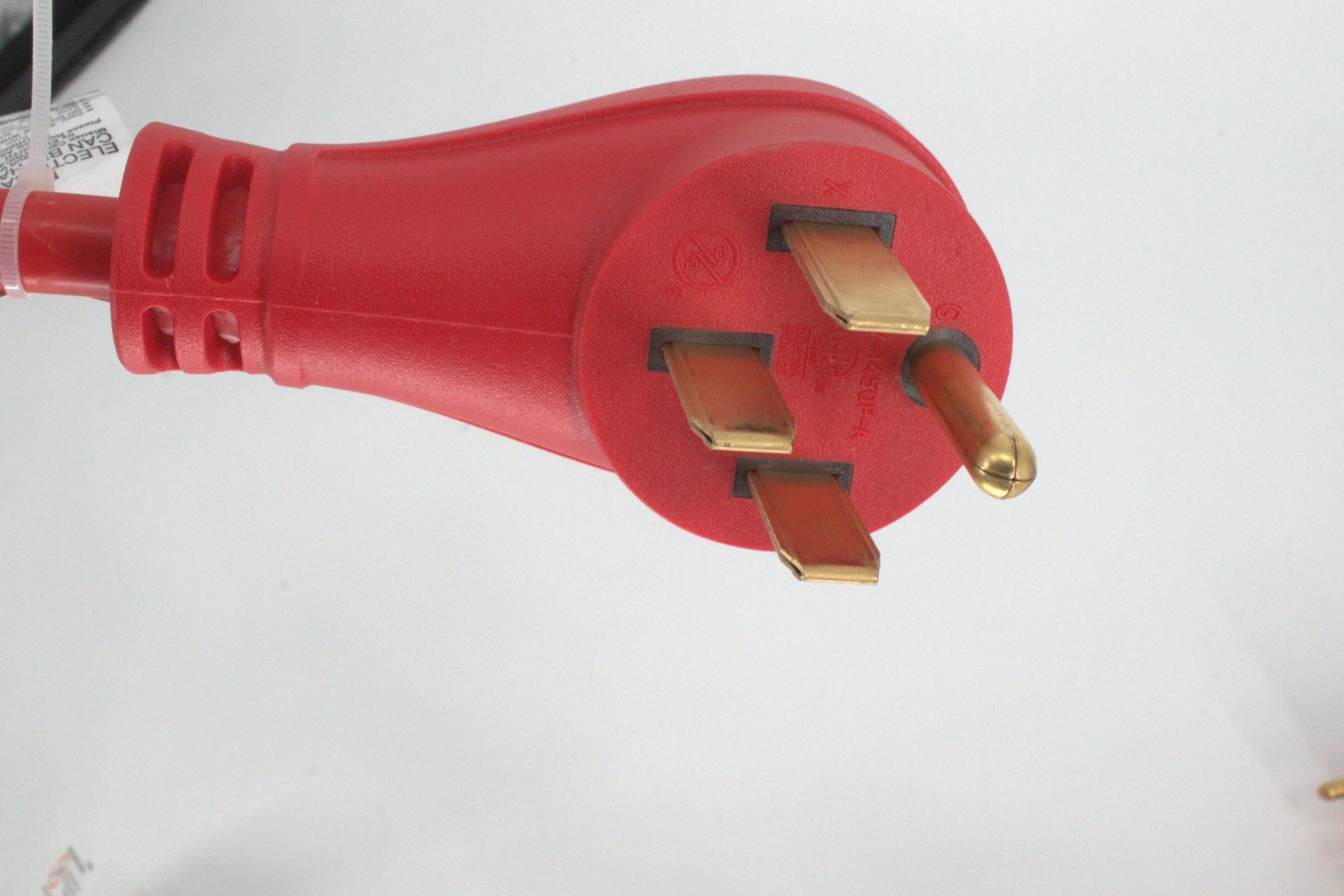 A close-up of the 50 Amp Generator Adapter Cord 14-50P to 3x 5-15R Outlets shows its red body and three metal prongs in a triangular layout, set against a white background.