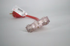 A close-up of the 50 Amp Generator Adapter Cord 14-50P to 3x 5-15R Outlets, featuring clear three-outlet connectors and a red heavy-duty cord. The adapter and plug are visible but out of focus in the background.
