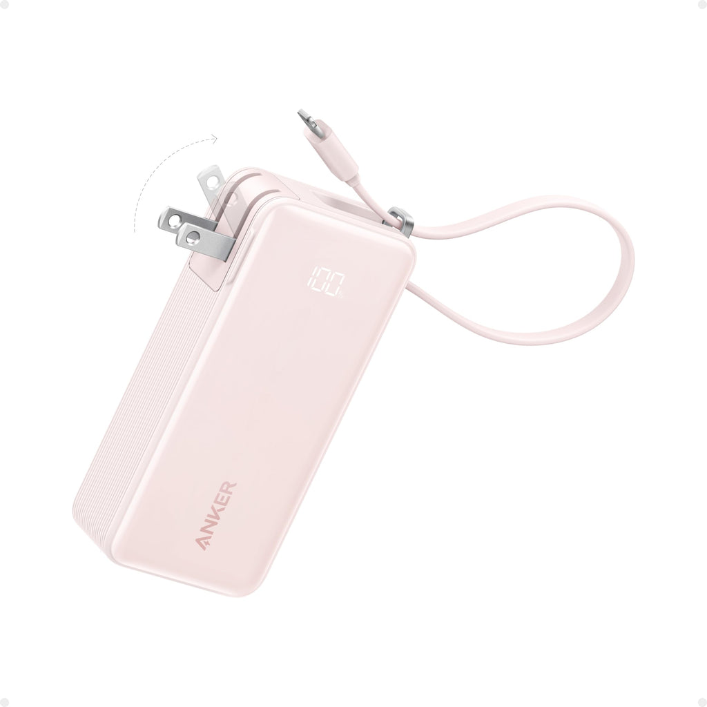 The Anker Power Bank (10K, Fusion, Built-In Cable) is shown in pink with a digital display, foldable wall plug, and an attached USB-C charging cable neatly wrapped around it on a white background.
